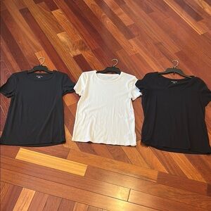 Women large Amazon tops in white and black. One top has a wider neckline.